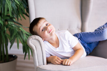 Obraz premium little boy in white t-shirt posing. Portrait of a fashionable male child. The concept of children's style and fashion.
