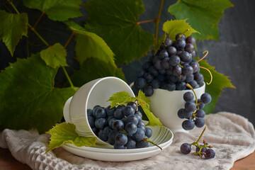 Grapes on a white saucer and a dark background.