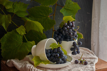 Grapes on a white saucer and a dark background.