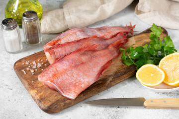 Grouper. Sea bass on a wooden Board on a light gray kitchen table. Raw sea bass closeup