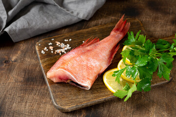 Grouper. Sea bass on a wooden Board on a brown wooden table. Raw sea bass. Copyspace
