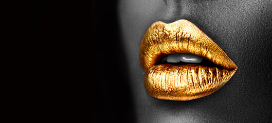 Golden lipstick closeup. Gold metal lips. Beautiful makeup. Sexy lips, bright lip gloss paint on beauty model girl's mouth, close-up. Lipstick. Black and white image