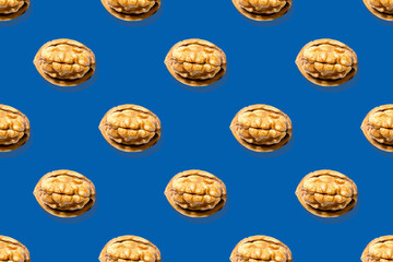 Fototapeta na wymiar Seamless pattern from isolated images of walnut on a blue background. Oil paint technique