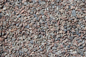 Crushed stone of different colors lies on the road.