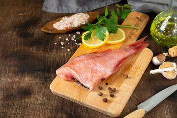 Grouper. Sea bass on a wooden Board on a brown wooden table. Raw sea bass. Copyspace