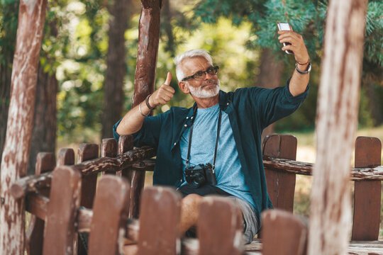 A Positive Retired Citizen Takes A Selfie In The Park. Active Lifestyle.