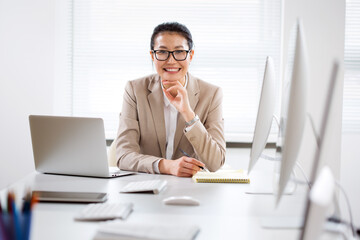 Asian business woman smiling at camera in an office