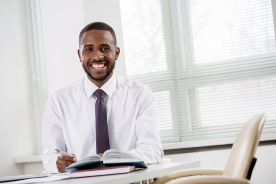 Happy handsome africanamerican businessman smiling while looking at camera in office