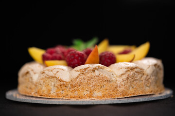 Sweet cake with fruits isolated on black background. Copy space. High quality photo