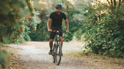 A man rides a bicycle through the forest, active lifestyle, sports.