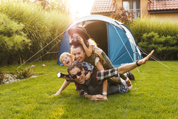 Family having fun camping in their house garden