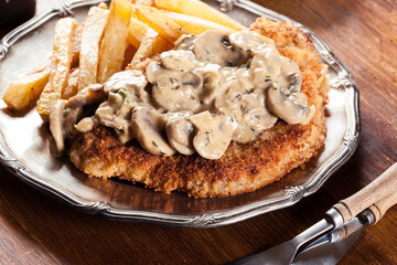 Traditional hunter schnitzel with a mushroom gravy and french fries