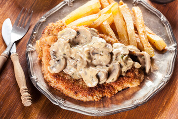 Traditional hunter schnitzel with a mushroom gravy and french fries