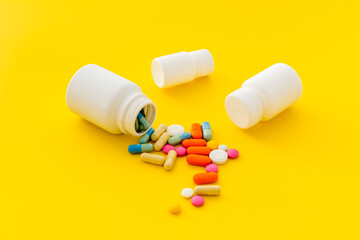 Medical pills and tablets spilling out of bottle, copy space