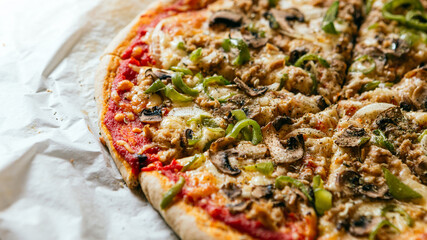 Close-up of a delicious homemade italian pizza with cheese, tomatoes, mushrooms and green pepper