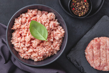 Raw minced meat in bowl on black table