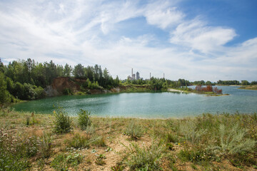Fototapeta na wymiar Flooded open pit quarry with blue water lake