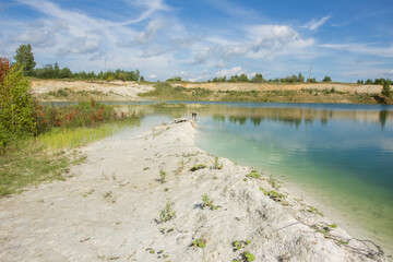 Fototapeta premium Flooded open pit quarry with blue water lake