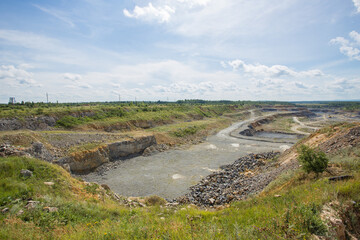 Big open pit limestone quarry mine with working drilling machines, excavators, trucks