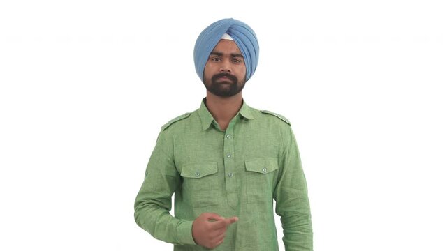 Portrait of beard Indian man pointing finger to right side and nodding his head, approving something. Isolated on white background