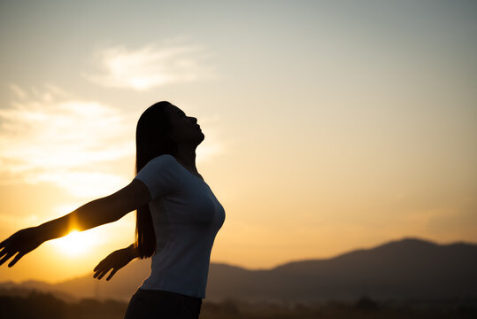 Silhouette of happy woman spreading arms and watching the mountain. Travel Lifestyle success concept adventure active vacations outdoor freedom emotions.