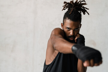 Image of athletic african american sportsman boxing while working out