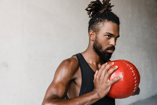 Image of african american sportsman working out with medicine ball