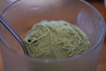 Green tea matcha ice cream scoop in glass bowl