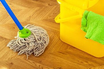 Floor cleaning mop and rag on yellow bucket. The cleaner will create hygiene on the house. Cleaning service