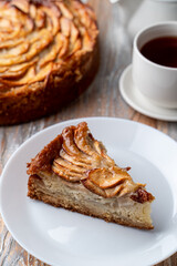 Homemade apple tart with apple slices on a white plate