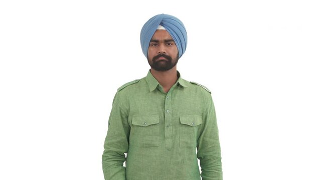 Portrait of Indian beard man showing thumbs down and shaking head with a displeased look. Isolated on white background.