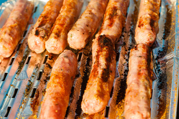 Sausages meat grilling on gas grill