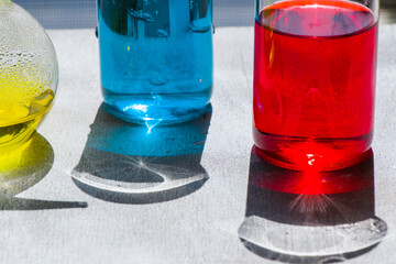 Laboratory glassware with red and blue color reagents