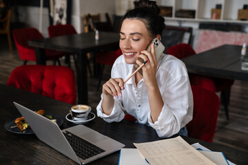 Smiling young woman studying on laptop computer