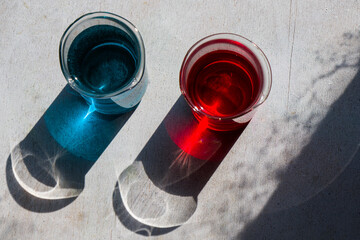 Laboratory glassware with red and blue color reagents