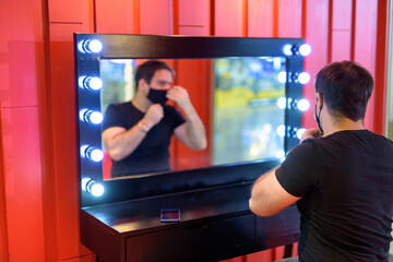 Persian man wearing mask against mirror in the makeup room