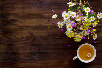 Mug of chamomile tea with fresh flowers top view
