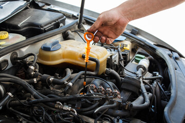 Fototapeta na wymiar man independently checks the oil level in the car. DIY car service