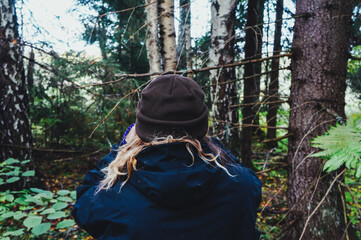 back view of a girl walking through the forest in warm clothes