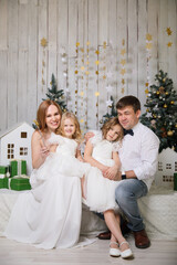 family with two daughters in Christmas decorations. happy and fun holidays. new year vacations. traditional annual photo shoot.