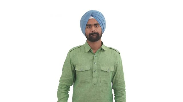 Portrait of young Indian man closed his mouth with imaginary zipper and throwing the key. Gesture of silence and swearing not to tell. Isolated on white background