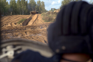Armored personnel carrier and a group of soldiers at firing position. Battlefield. View from the...