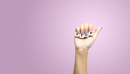 Beautiful woman's hand raising in fist pose and holding white alphabet cube arranged into word...