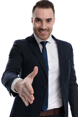 Cheerful businessman reaching for a hand shake and smiling