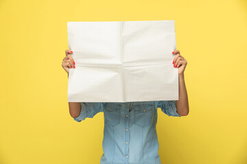 Young casual woman covering her face with newspaper