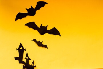 Halloween concept. Halloween house and two bats on an orange background. Empty background for text and design.