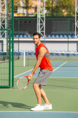 Handsome sportsman playing tennis on tennis court