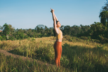 Calm woman in Upward Salute Pose doing yoga in nature