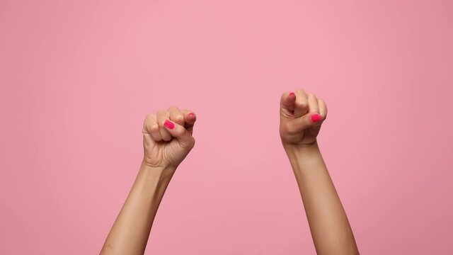 woman hands pointing fingers, making thumbs up gesture and celebrating victory on pink background