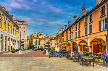 Fototapeta na wymiar Typical italian buildings and tables of street restaurants on Piazza del Mercato Market square in Brescia city historical centre, evening twilight view, Italian street, Lombardy, Northern Italy
